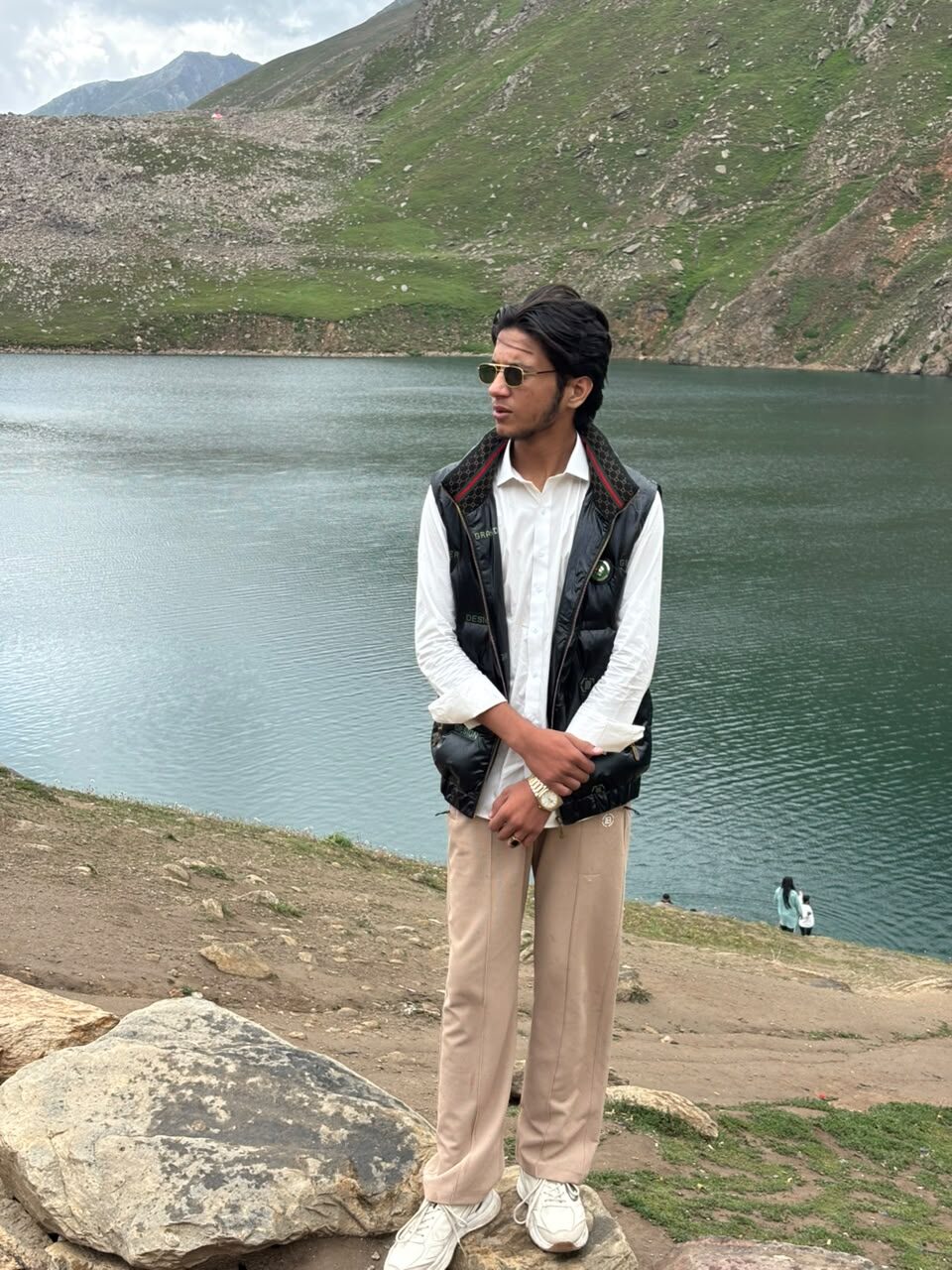 Ahmad Safdar standing beside an alpine lake in northern Pakistan