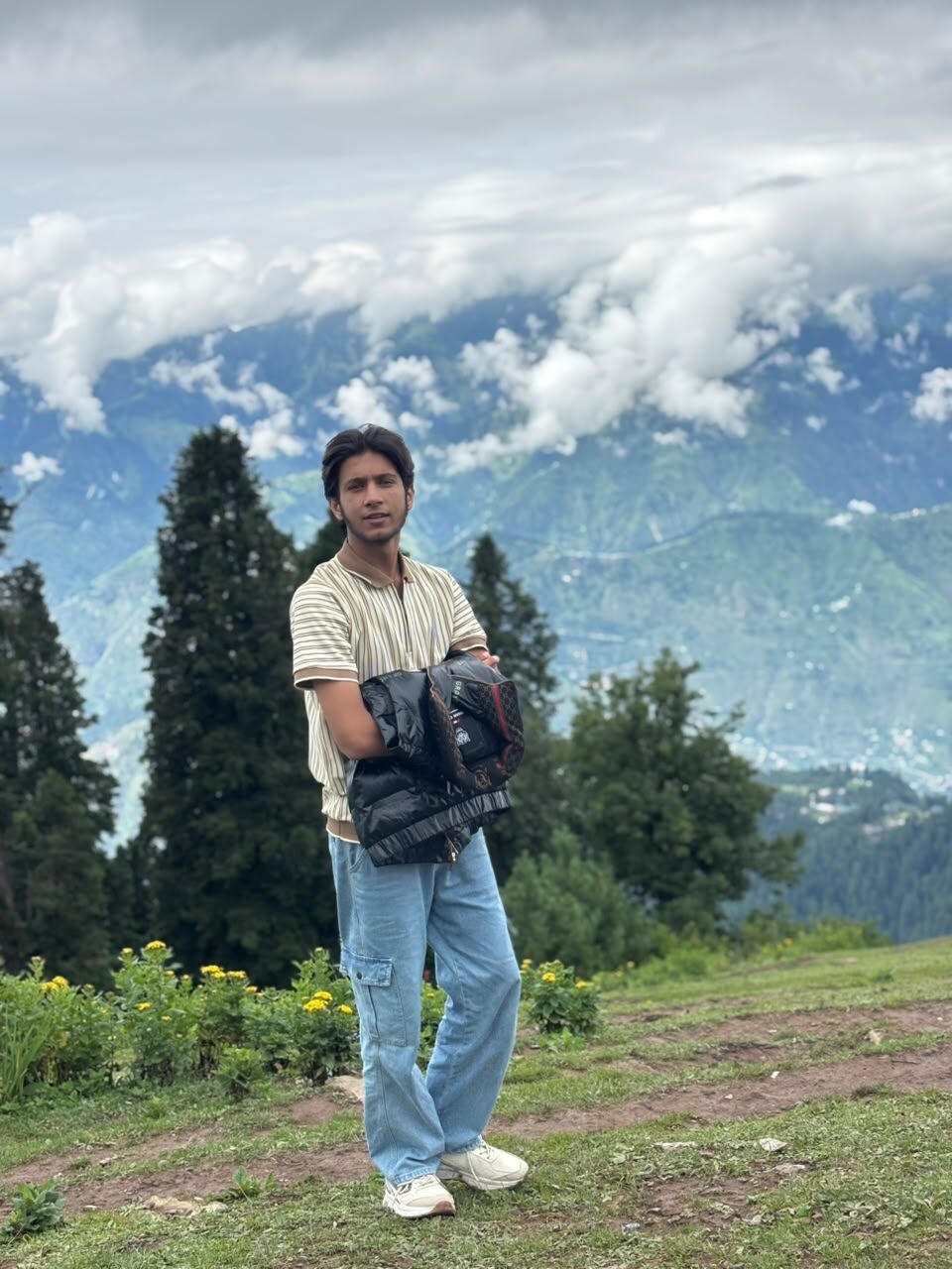 Ahmad Safdar standing on a hillside above the clouds